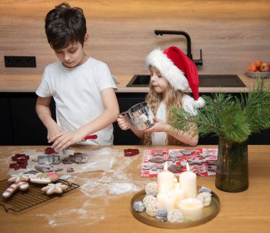 Noel tatiline hazırlanıyorum. Çocuklar - bir erkek ve bir kız mutfakta zencefilli ekmek hazırlıyorlar.