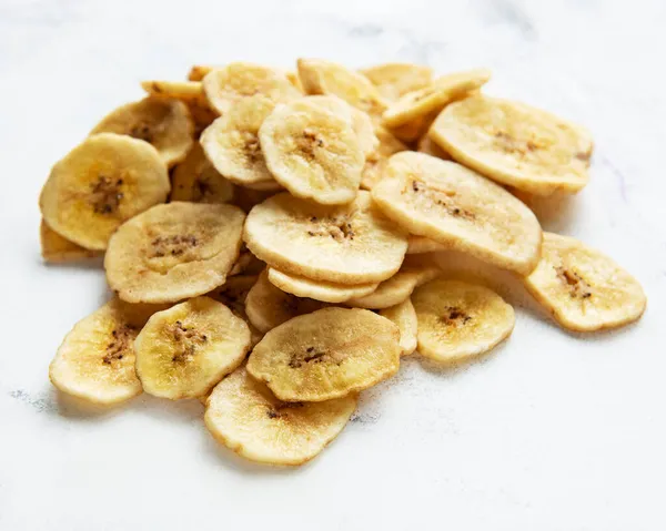 Gedroogde Gekonfijte Bananenschijfjes Chips Een Witte Marmeren Achtergrond — Stockfoto