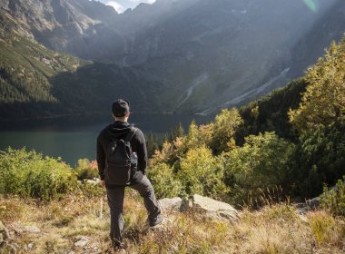 Yürüyüş yapan adam açık hava yaşam tarzıyla seyahat ediyor. Genç gezgin dağ manzarasında yürüyüş yapıyor.