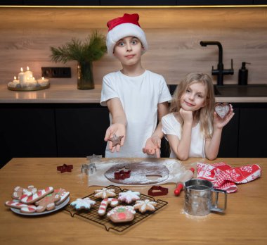 Noel tatiline hazırlanıyorum. Çocuklar - bir erkek ve bir kız mutfakta zencefilli ekmek hazırlıyorlar.