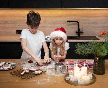 Noel tatiline hazırlanıyorum. Çocuklar - bir erkek ve bir kız mutfakta zencefilli ekmek hazırlıyorlar.
