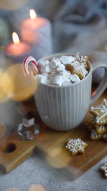 Kahverengi kağıda sarılmış Noel hediyeleri. Masada yanan mum.