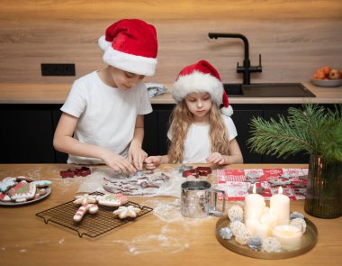 Noel tatiline hazırlanıyorum. Çocuklar - bir erkek ve bir kız mutfakta zencefilli ekmek hazırlıyorlar.