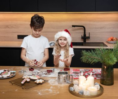 Noel tatiline hazırlanıyorum. Çocuklar - bir erkek ve bir kız mutfakta zencefilli ekmek hazırlıyorlar.
