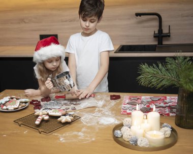 Noel tatiline hazırlanıyorum. Çocuklar - bir erkek ve bir kız mutfakta zencefilli ekmek hazırlıyorlar.