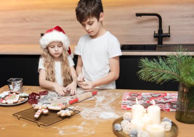 Noel tatiline hazırlanıyorum. Çocuklar - bir erkek ve bir kız mutfakta zencefilli ekmek hazırlıyorlar.