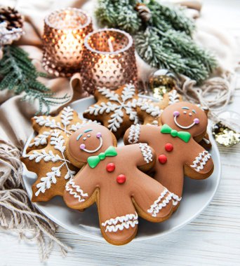 Tabakta Noel kurabiyesi ve beyaz ahşap arka planda mumlar. Üst görünüm