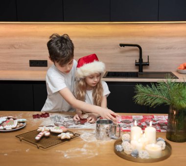 Noel tatiline hazırlanıyorum. Çocuklar - bir erkek ve bir kız mutfakta zencefilli ekmek hazırlıyorlar.