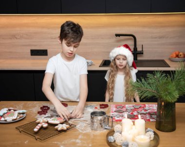 Noel tatiline hazırlanıyorum. Çocuklar - bir erkek ve bir kız mutfakta zencefilli ekmek hazırlıyorlar.