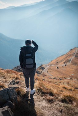 Yakışıklı genç adam güneşli bir günde dağların önüne bakıyor. Kasprowy Wierch. Polonya. 