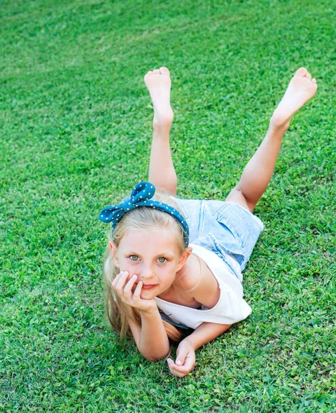 Cheerful Little Girl Denim Jumpsuit Lying Green Grass — Stock Photo, Image