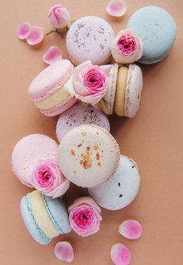 Kahverengi arka planda güzel gülleri olan lezzetli badem kurabiyeleri.