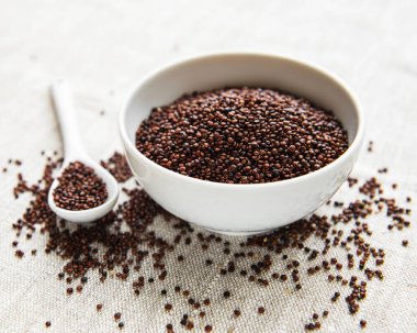 Eski bir tekstil arka planında kırmızı kinoa tohumları