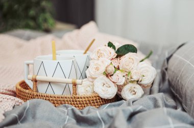 Hasır tepsi, bir fincan kahve ve gül çiçeği. Yatakta kahvaltı. Şık bir iç dekorasyon. Üst görünüm