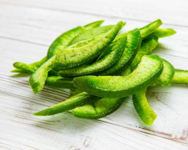 Beyaz ahşap bir arka planda, bir tabakta kuru bir parça pomelo.