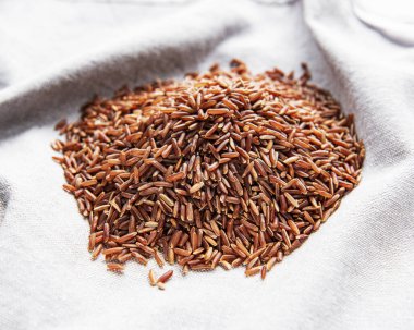 Gri bir arka planda ham kırmızı pirinç. 