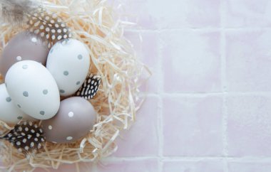 Pembe fayanslı saman yuvasında Paskalya yumurtaları