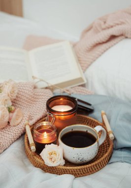 Yatakta romantik kahvaltı. Hygge konsepti. Yatakta bir tepsi kahve ve mum..