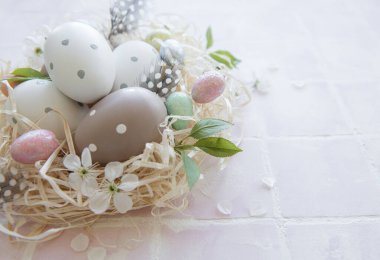 Pembe fayanslı saman yuvasında Paskalya yumurtaları