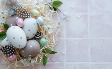 Pembe fayanslı saman yuvasında Paskalya yumurtaları