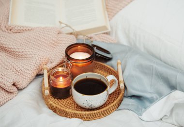 Yatakta romantik kahvaltı. Hygge konsepti. Yatakta bir tepsi kahve ve mum..