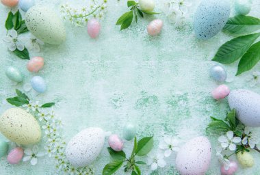 Yeşil ahşap arka planda renkli paskalya yumurtalarının üst görüntüsü