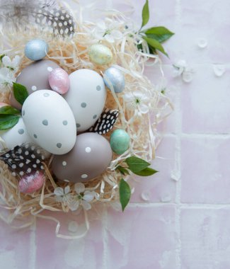 Pembe fayanslı saman yuvasında Paskalya yumurtaları