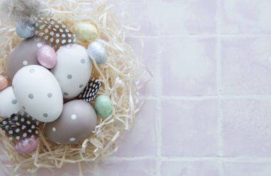 Pembe fayanslı saman yuvasında Paskalya yumurtaları