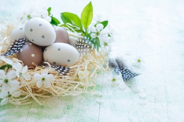 Yeşil ahşap arka planda saman yuvasındaki Paskalya yumurtaları