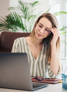 Ofisindeki bilgisayarda çalışan genç bir kadın.