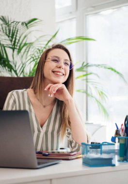 Ofisindeki bilgisayarda çalışan genç bir kadın.