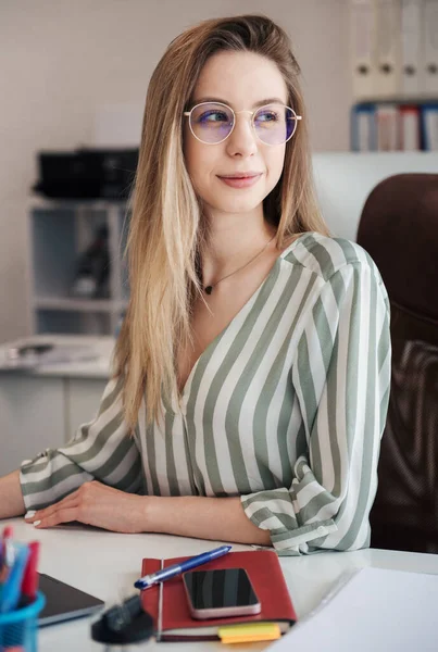 Ofisindeki bilgisayarda çalışan genç bir kadın.