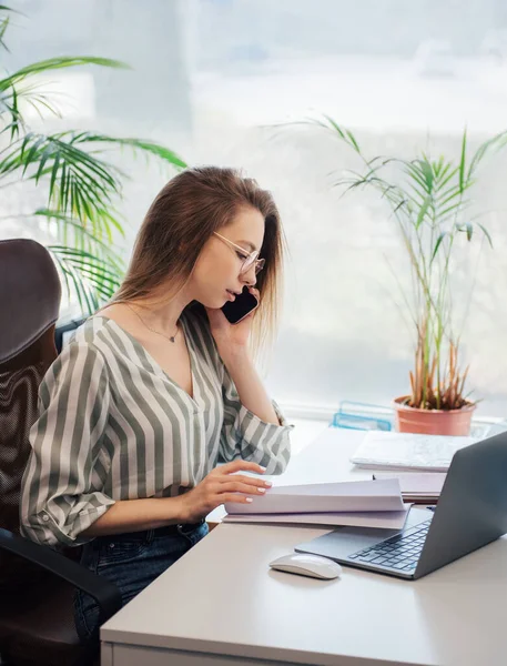 Ofisindeki bilgisayarda çalışan genç bir kadın.