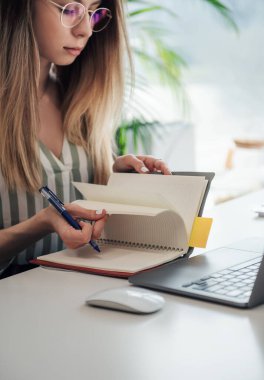 Ofisindeki bilgisayarda çalışan genç bir kadın.