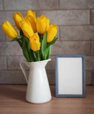 Güzel sarı lale çiçekleri ve mutfak masasındaki boş resim çerçevesi.
