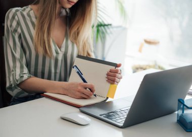 Ofisindeki bilgisayarda çalışan genç bir kadın.