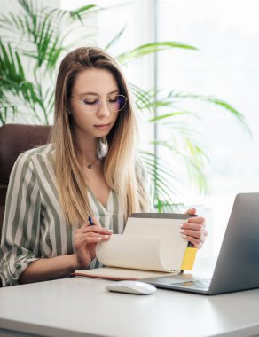 Ofisindeki bilgisayarda çalışan genç bir kadın.