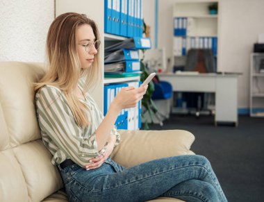 Ofisindeki bilgisayarda çalışan genç bir kadın.