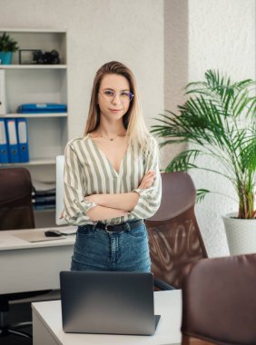 Ofisindeki bilgisayarda çalışan genç bir kadın.