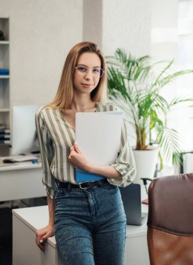 Ofisindeki bilgisayarda çalışan genç bir kadın.