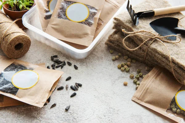 Microgreen seeds in paper bags and microgreen sowing equipment on the table. Healthy food.