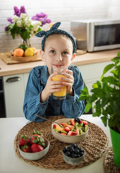Healthy food at home. Cute little girl eats fruit salad