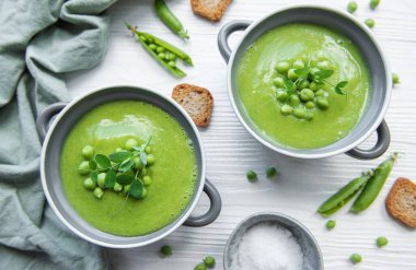 Fresh green pea soup bowl on gray concrete background