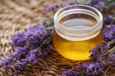 Glass of honey, honeycomb and lavender flowers