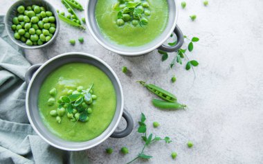 Fresh green pea soup bowl on gray concrete background