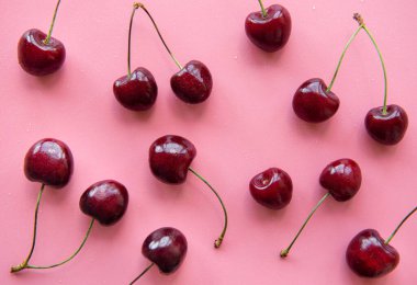 Fresh red cherries fruit on a pink background