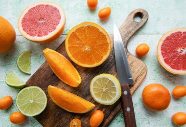 Tahtada bıçakla taze narenciye dilimlenmiş.