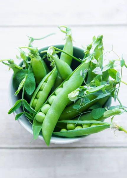 緑のエンドウ豆の若い新鮮なジューシーなポッドをコンクリートの背景にボウル 健康的な有機食品 — ストック写真