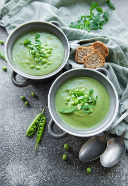 Fresh green pea soup bowl on gray concrete background