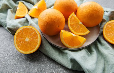 Koyu beton zeminde taze taze portakallar.